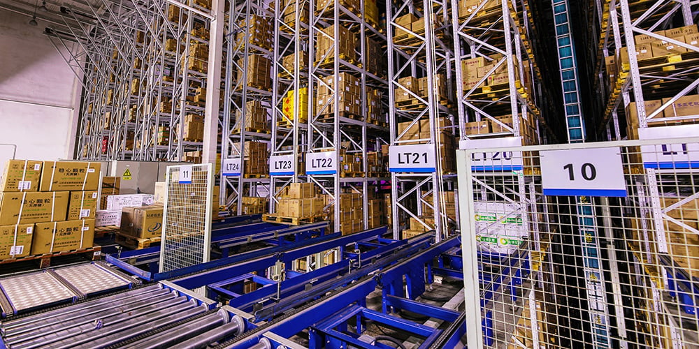 ASRS automated racking system with shuttle conveyors and high-density pallet storage inside a modern warehouse.