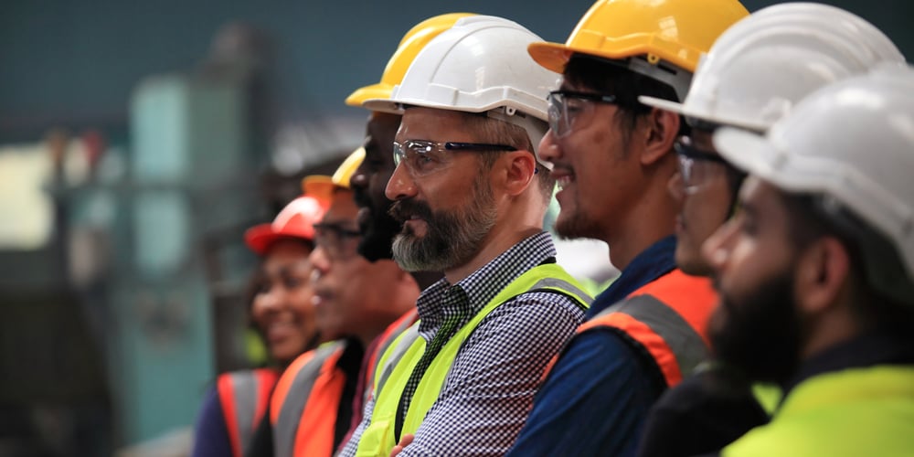 Warehouse workers and staff wearing safety gear and working together to maintain a safe and efficient warehouse environment