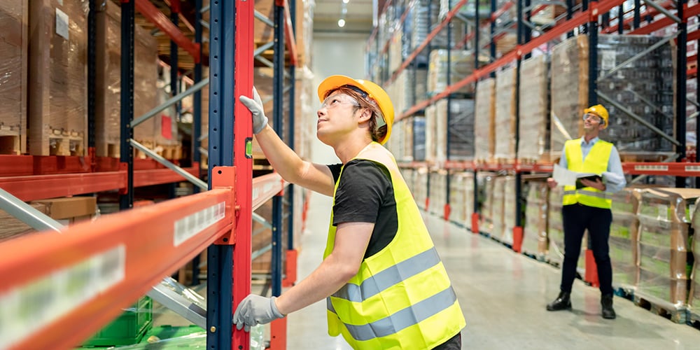 Warehouse worker inspecting pallet racks after installation