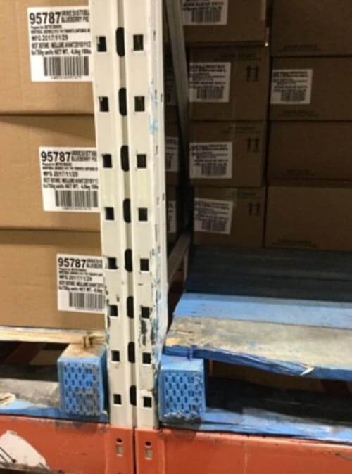 Improper storage clearance between pallet and rack column.