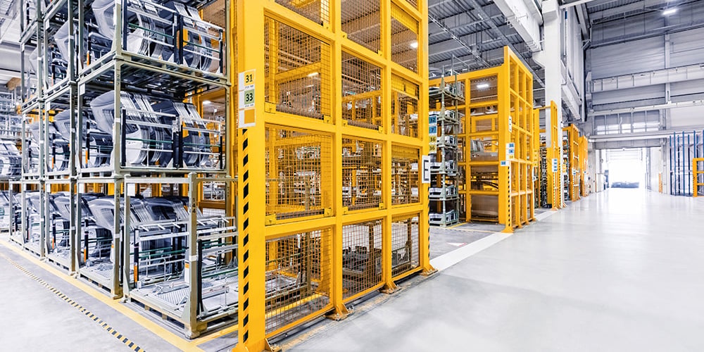 Automotive warehouse with organized vehicle storage, racking systems, and forklift travel paths