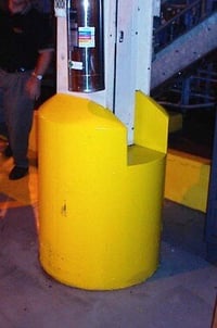 Yellow concrete-encased column base protecting a structural building column