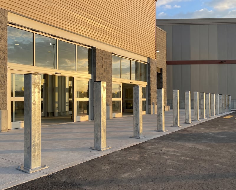 Exterior galvanized bollard in front of a shopping store