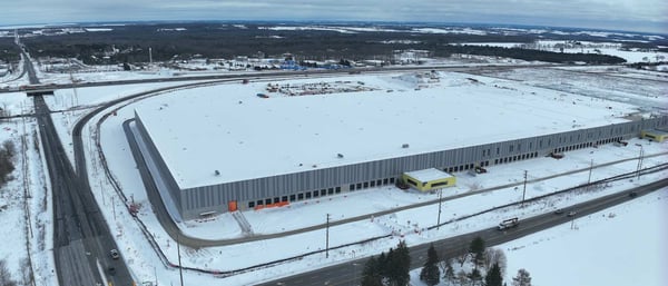 Exterior view of DSV Canada’s 1.3 million-square-foot Innisfil distribution center, showing the completed warehouse building with truck bays, dock doors, and surrounding lot.
