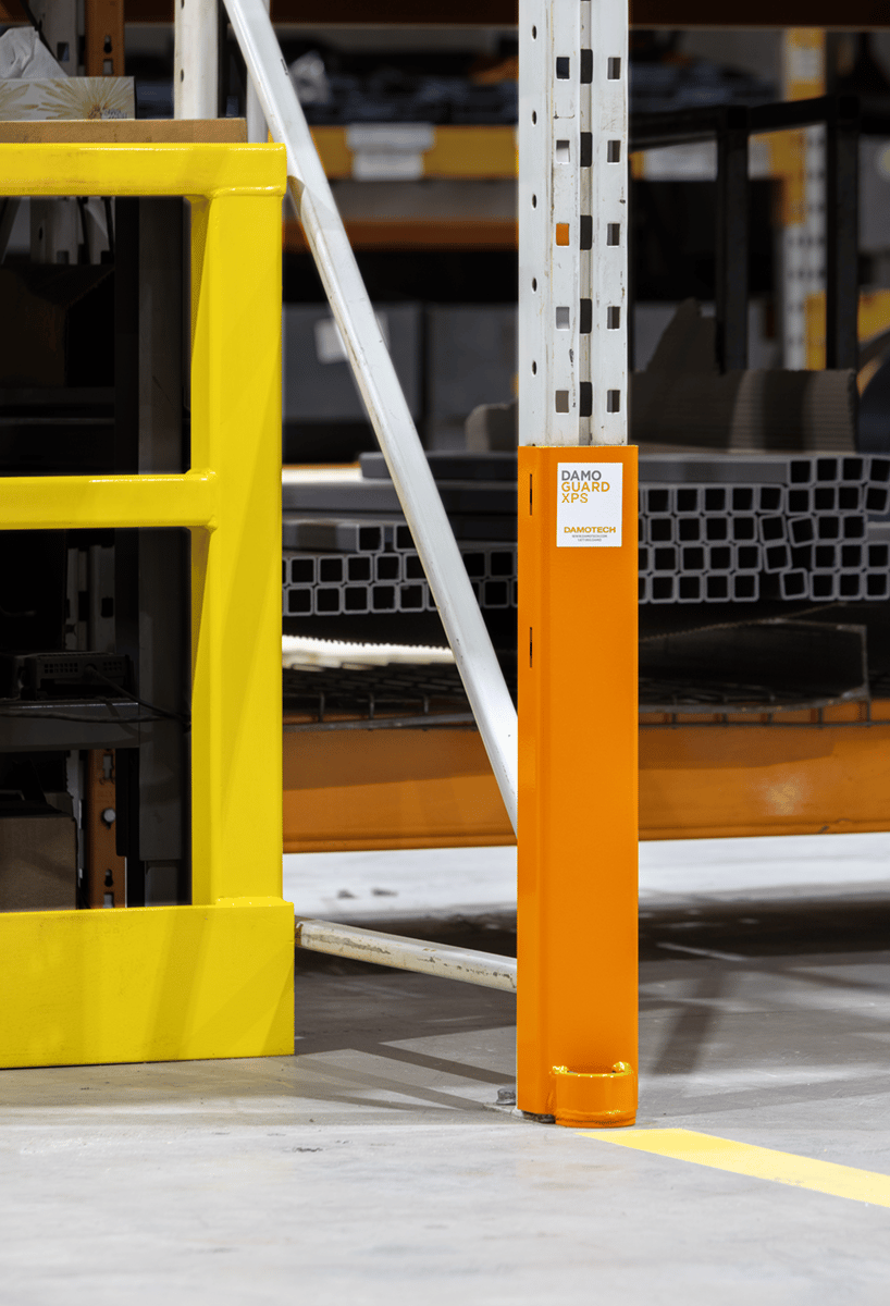 Orange DAMO Guard XPS anchored to a pallet rack upright in a warehouse