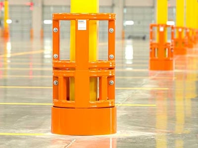 Orange DAMO SHIELD protecting parking lot columns in an indoor parking garage