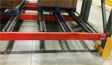 Bottom of a pallet rack level beam that is deformed