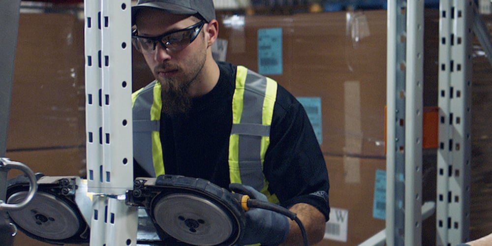 Man Installing a pallet rack repair kit on a upright