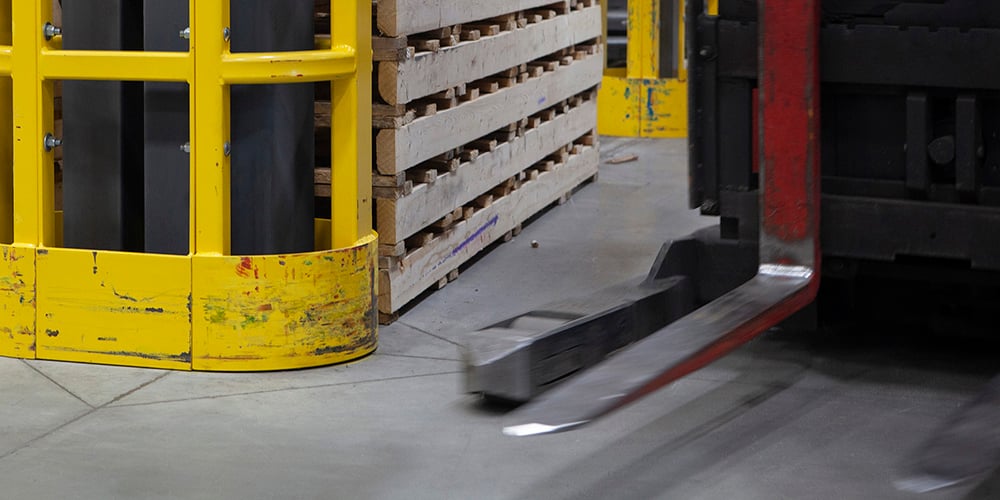 Forklift in a warehouse aisle next to pallets