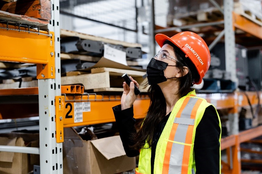 Kate inspecting a racking system in a warehouse.
