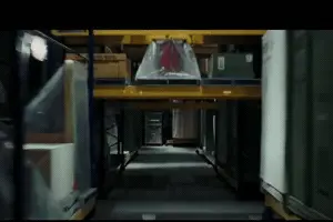 Bill Hader's character in a Night at the museum hits a racking tunnel and falls off the moving vehicule in a warehouse
