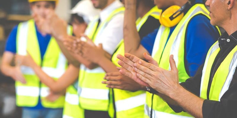 Des employés d’entrepôt applaudissent en raison d’une culture de travail positive