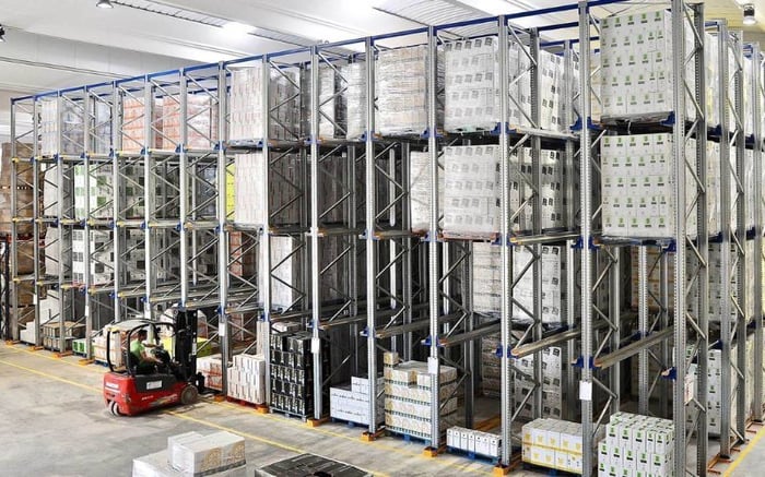 Drive-in racking system in a wine warehouse, featuring deep-lane storage for pallets of wine cases designed to maximize space using a Last-In, First-Out (LIFO) method.