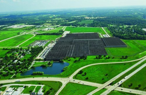 Exterior view of John Deere’s Parts Distribution Center in Milan, Illinois, showcasing the large industrial warehouse.