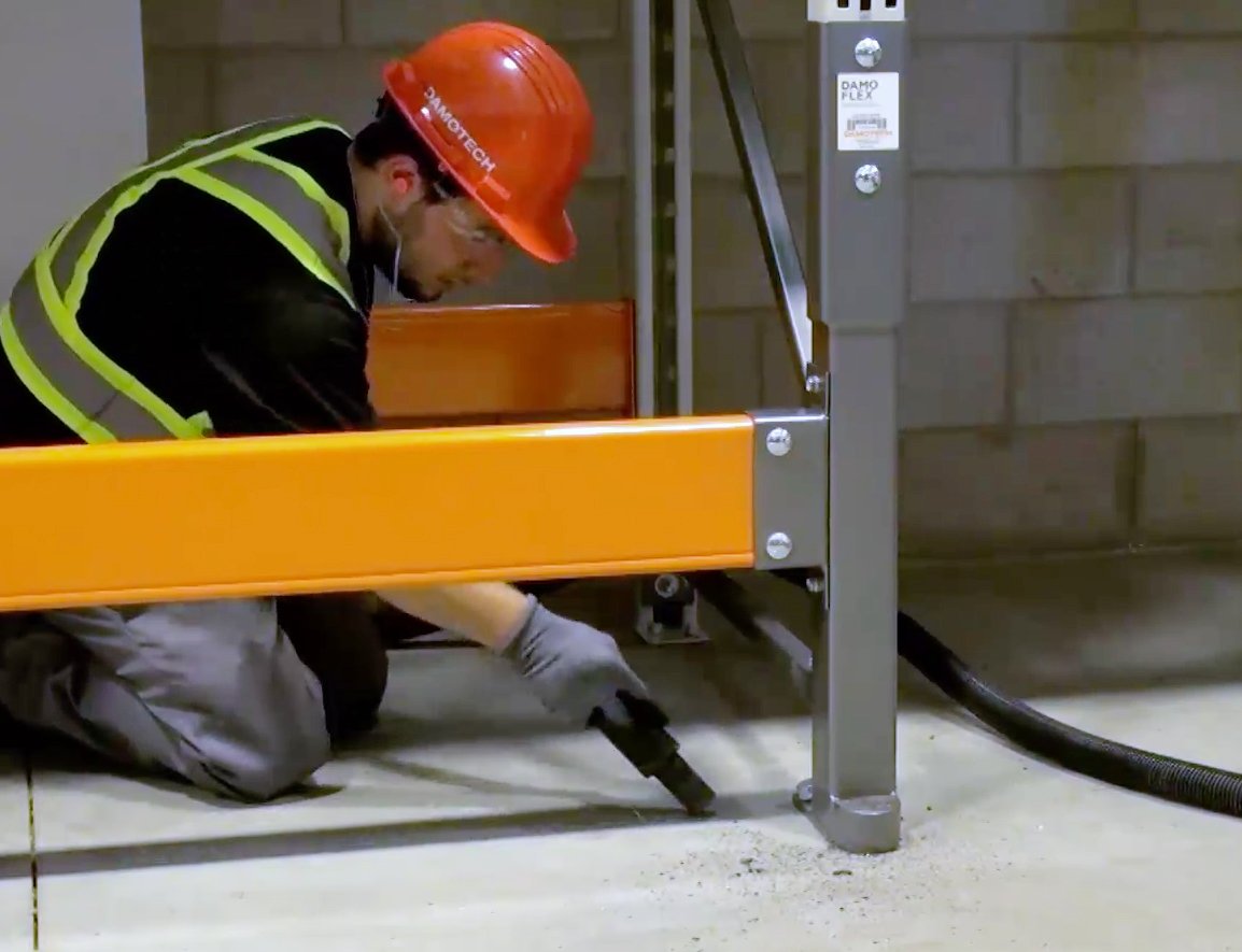 Man installing a Damo Flex on a pallet rack upright