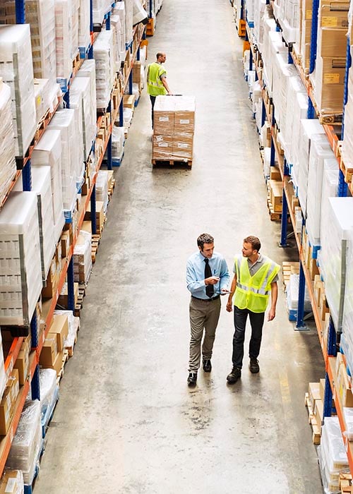 Employees walking and inspecting warehouse racking