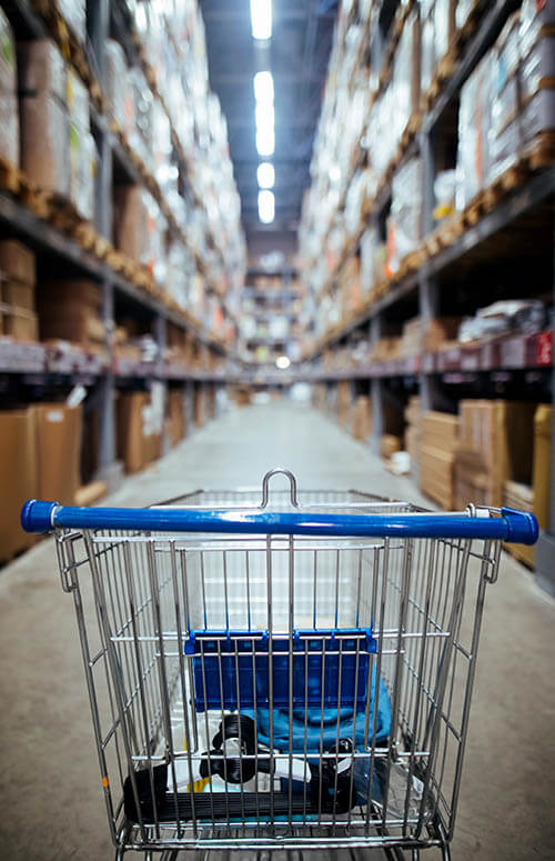 Shopping cart in the middle of a warehouse aisle